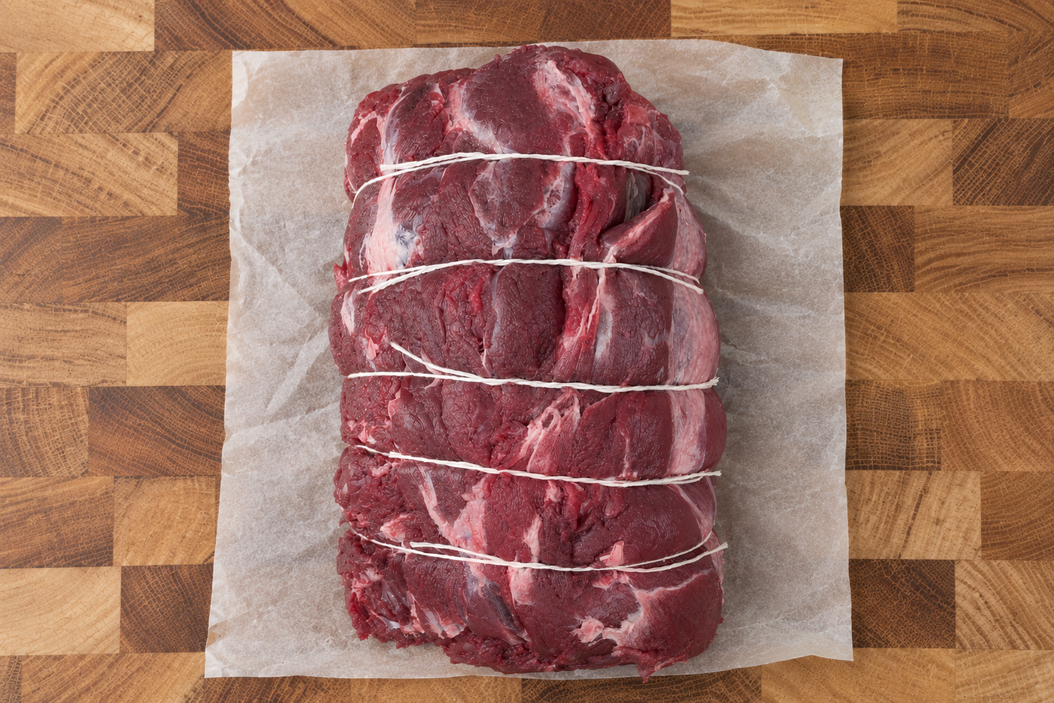 A haunch of venison with a brace of pheasant and partridge hung beside it
